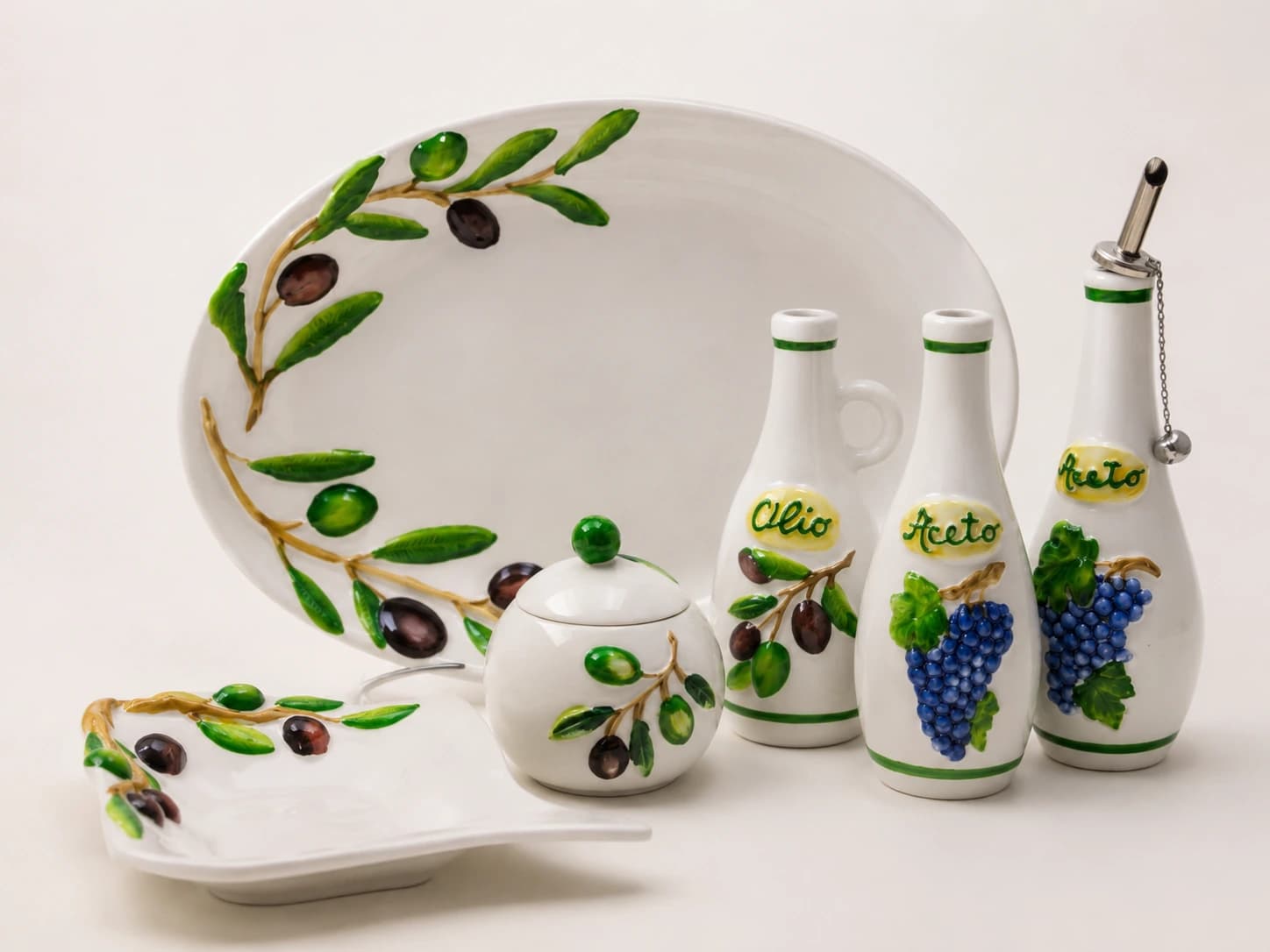 Servizio con bottiglie e piatto decorati a olive